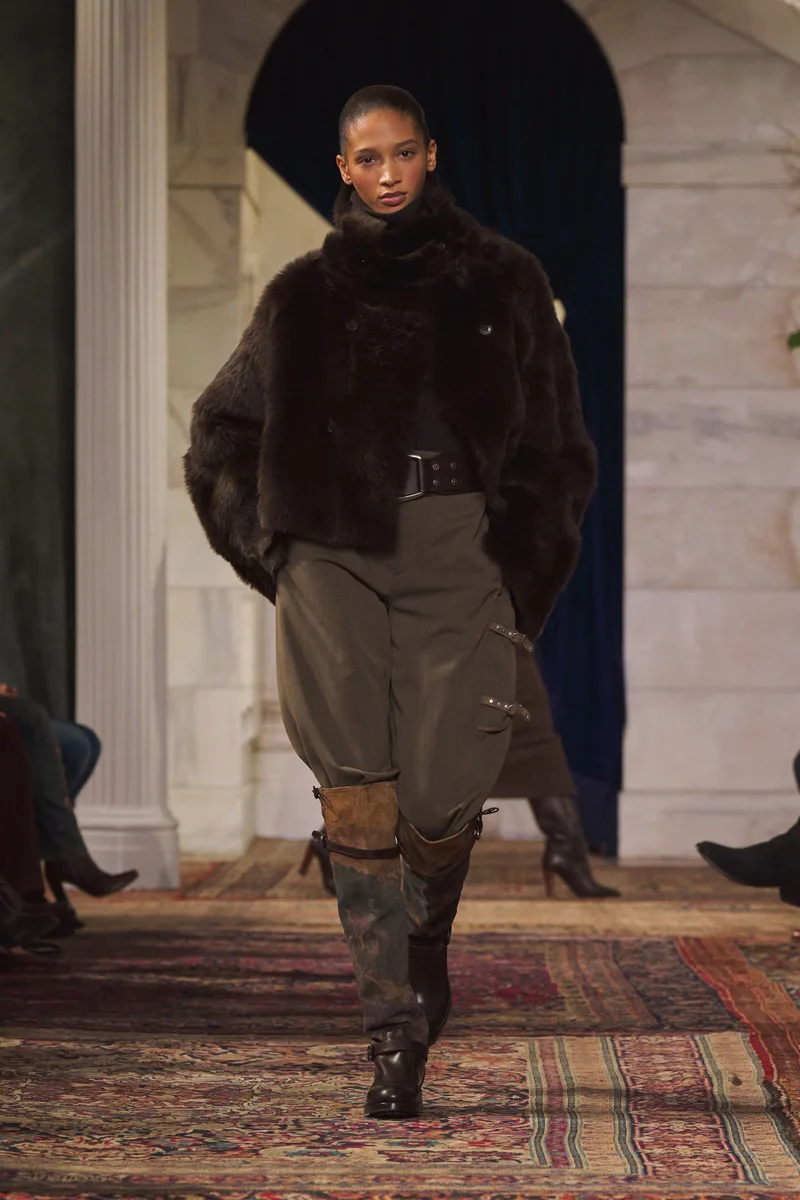 Модель Ralph Lauren у короткій темно-коричневій дублянці з поясом, штанах хакі і високих чоботах