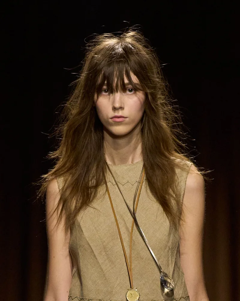 Модель Coach весна-літо 2027 зі стрижкою шегі на середнє волосся і довгим чубчиком
