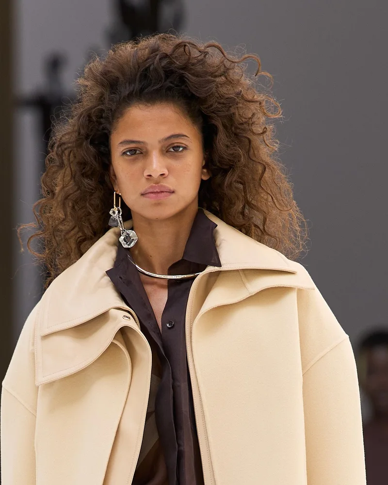 Модель Sportmax з густими темними кучерями до плечей