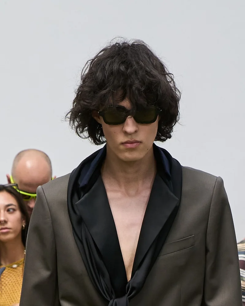 Модель Sacai з темними кучерями середньої довжини і сонцезахисними окулярами