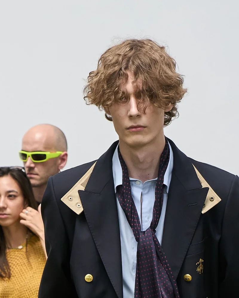 Модель Sacai з хвилястим русявим волоссям до підборіддя і пасмами на обличчі